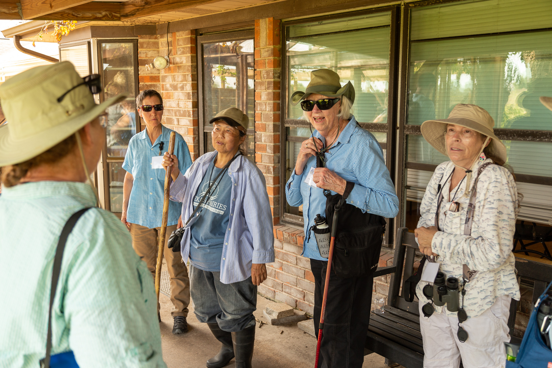 Group of people stand outside, ready for a hike.