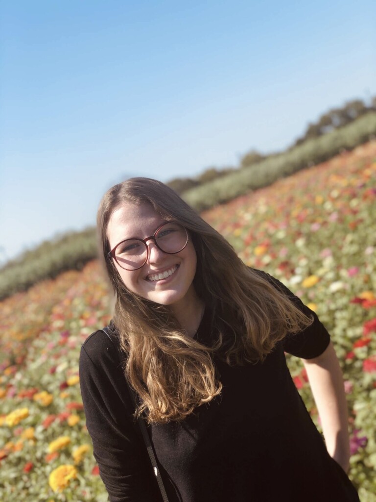 Image of young person standing in front of a field of wildflowers